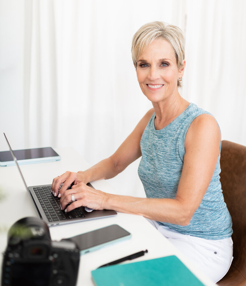 Angela Brown, Certified Professional Photographer, working on her laptop.