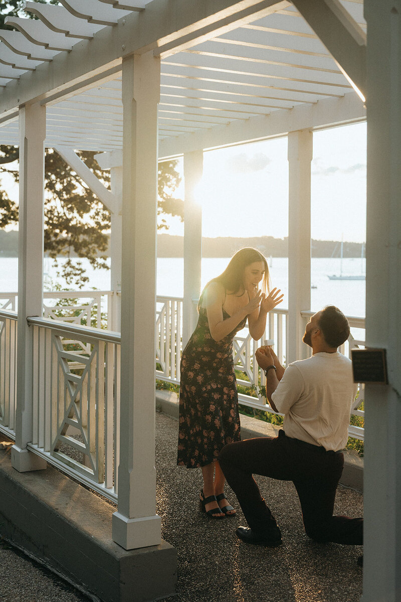 woman in shock during surprise proposal photos, captured by Elsie Goodman, an NYC engagement and couples photographer
