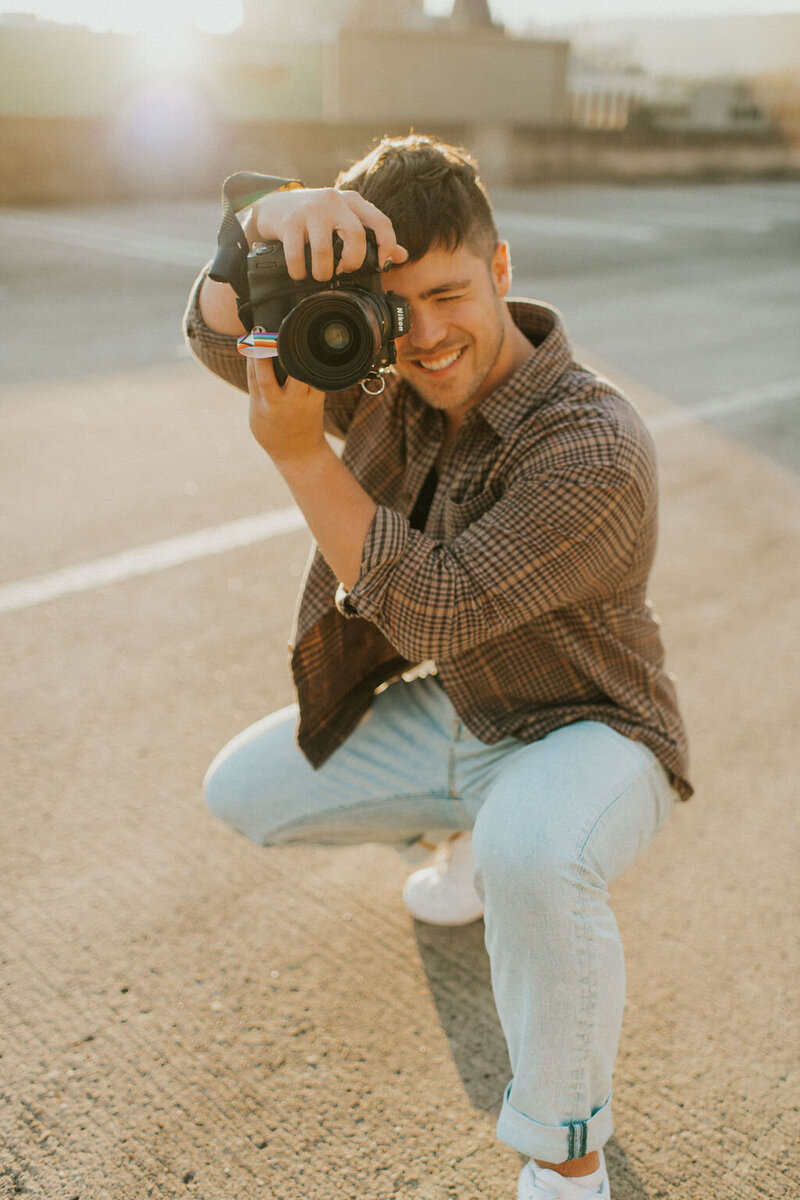 Portrait of NYC wedding and elopement photographer Dom Augustine standing outdoors, showcasing the face behind the camera.