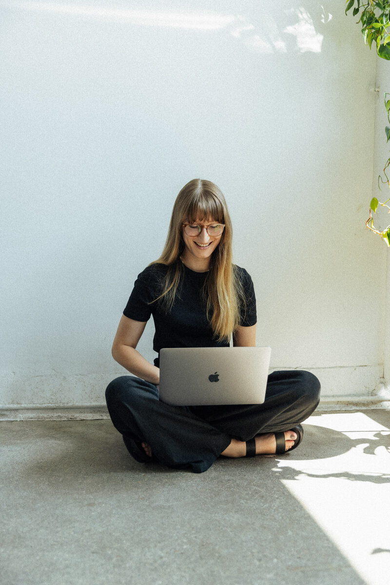 Person arbeitet konzentriert an ihrem Laptop, sitzend an einem Schreibtisch