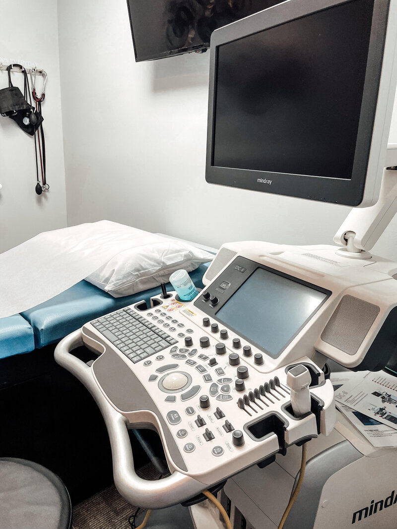 ultrasound machine and get sitting next to a blue exam table