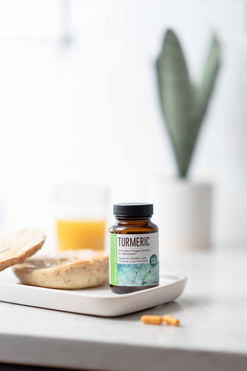 Photography of a supplement bottle and capsules with breakfast in a kitchen