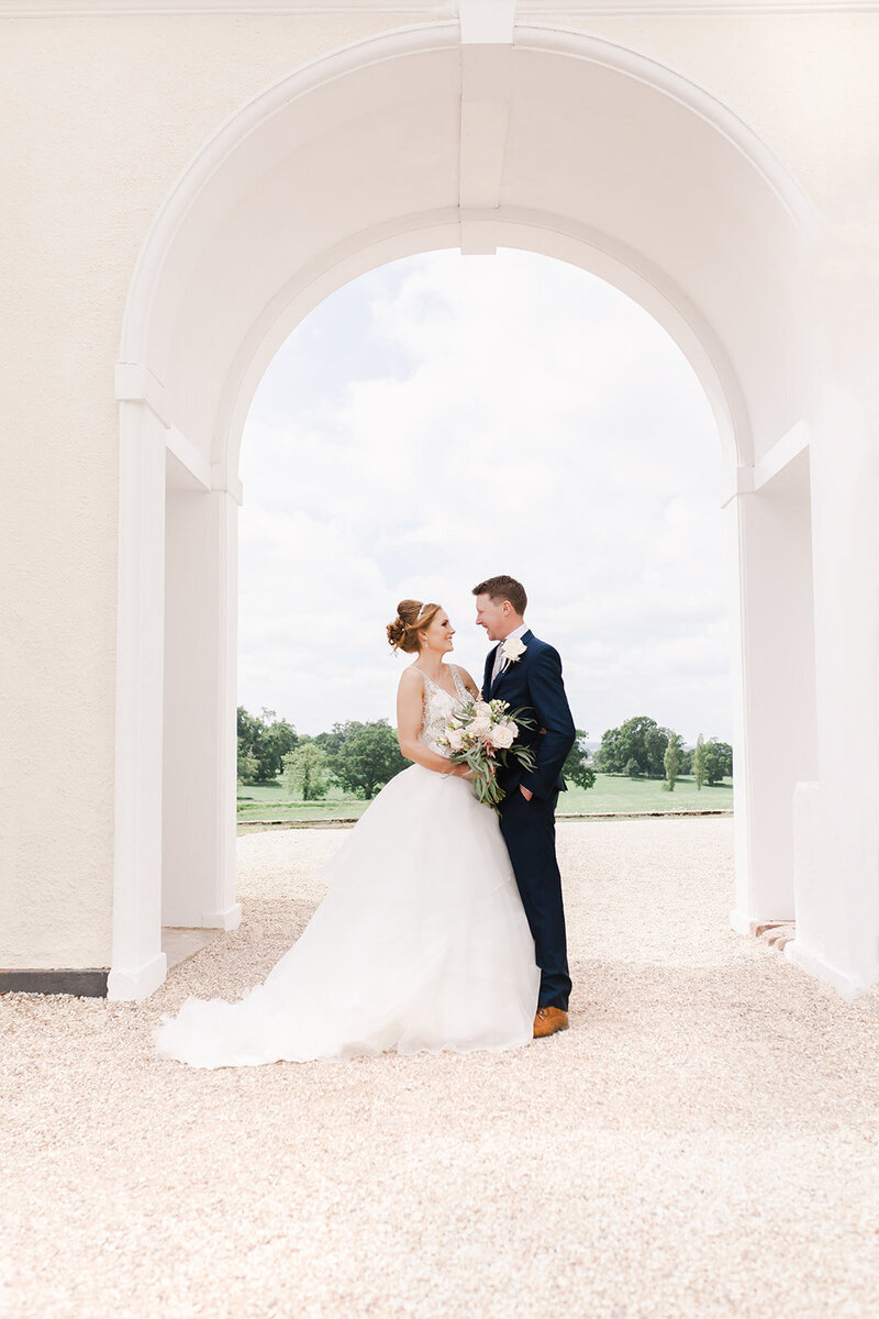 Elegant couple pose under the regency wedding venue arch