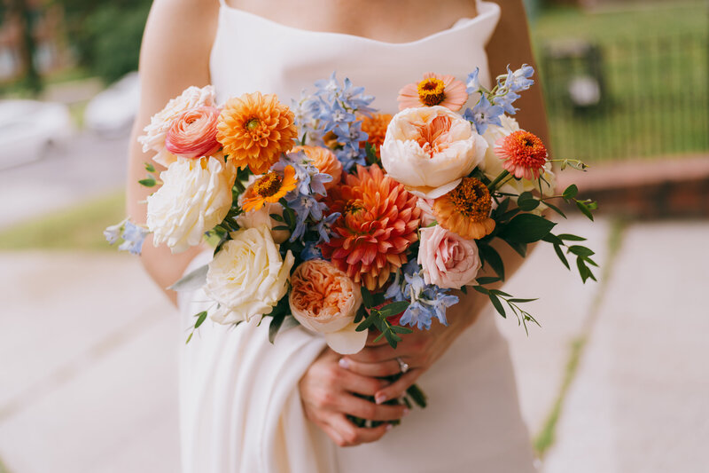 Wedding bouquet full of orange, pink and white flowers