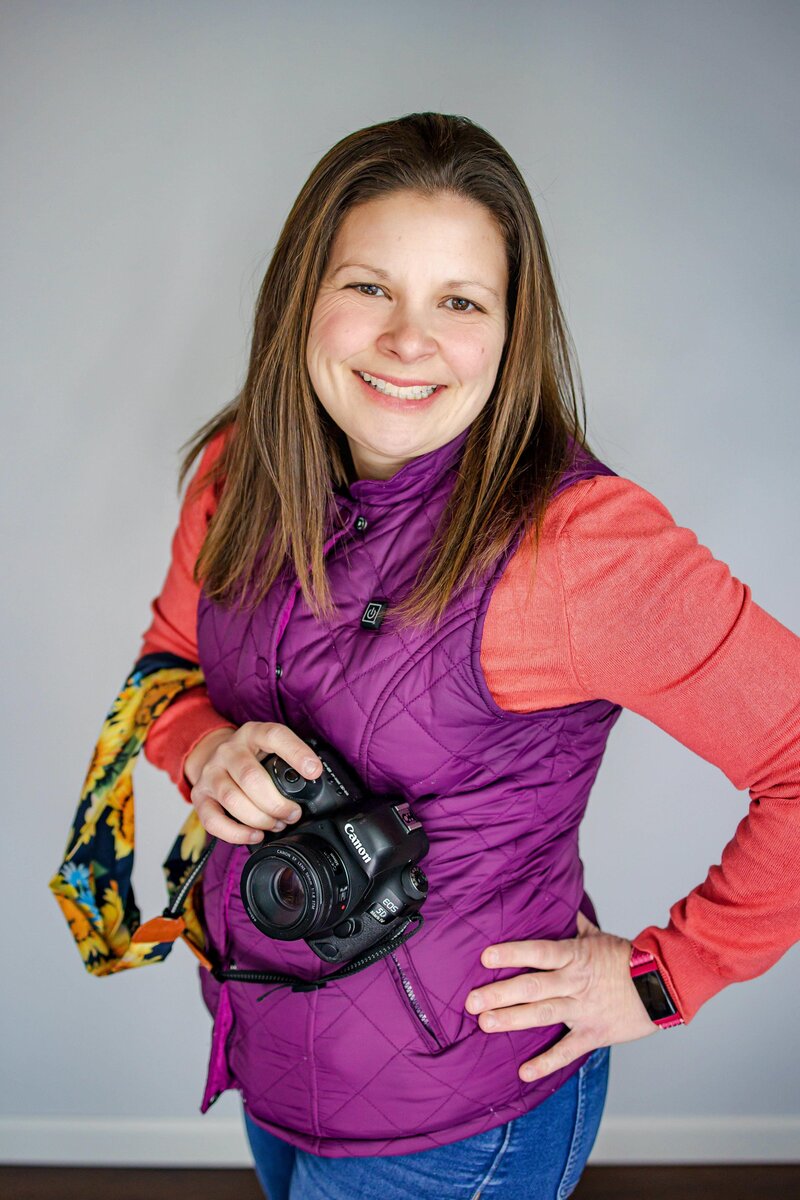 Photographer smiling and holding camera in Wauseon Studio