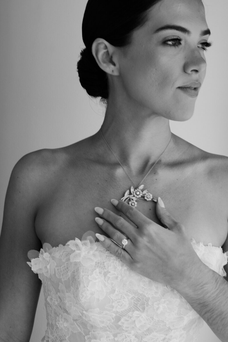 Closeup of a bride smiling and holding her hands up with diamond engagement ring