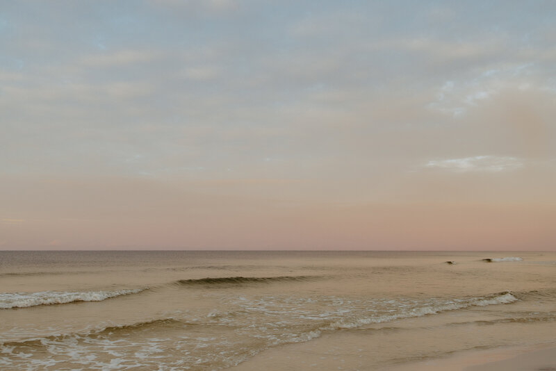 Family Photographer,  a calm ocean beneath a colorful sky at dusk