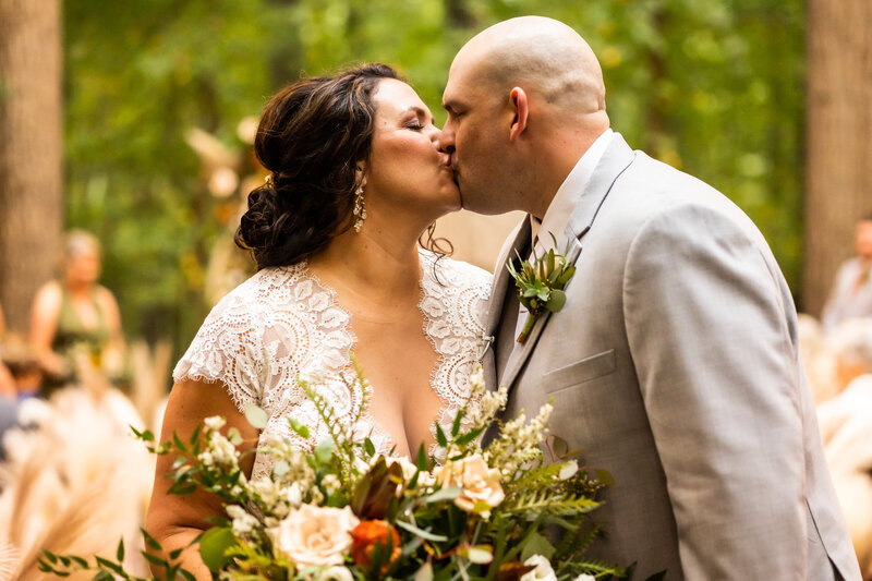 Newly weds kiss at the end of the aisle during a fall maryland wedding ceremony