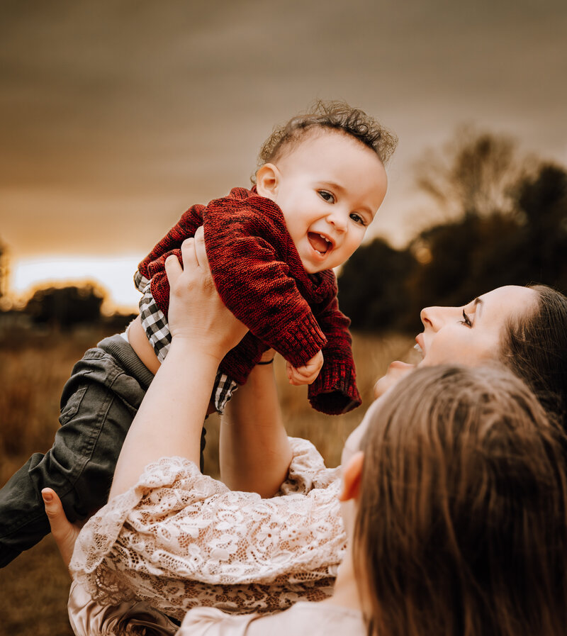 mom playing with toddler at sunset during family session