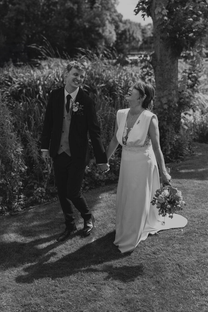 Wedding photographer captures couple taking a stroll hand in hand at their french chateau wedding.