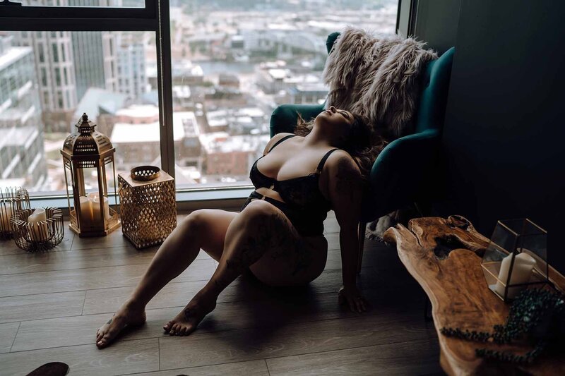 Curvy woman posing in front of window in a high rise in Nashville