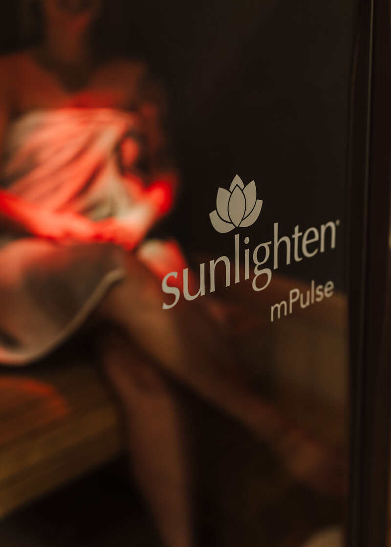 Relaxing in a Sunlighten mPulse infrared sauna during a wellness session promoting detox and relaxation.