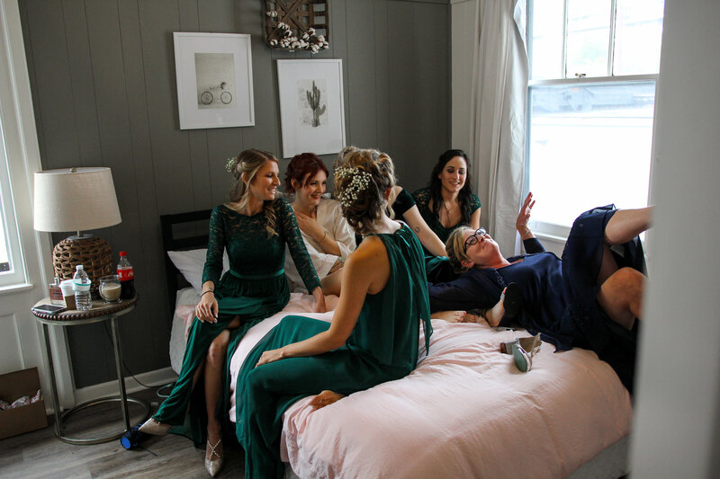 bridesmaids on a bed laughing
