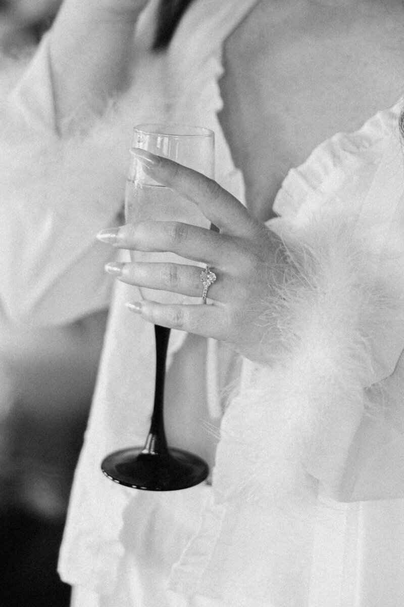 A bride sipping champagne while getting ready for her wedding day, captured in an elegant, editorial style. Photographed by Alexia Rodriquez, a destination wedding photographer specializing in timeless, luxury wedding imagery.