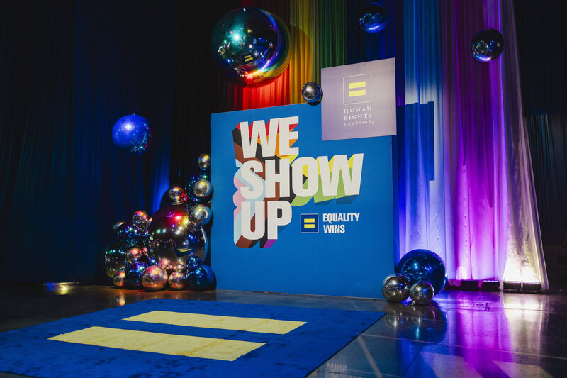 A stage set up with a large backdrop and balloons 