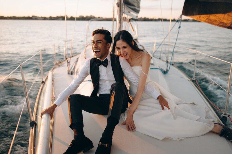 Couple laughing on a sailboat for their Toronto sailing elopement.