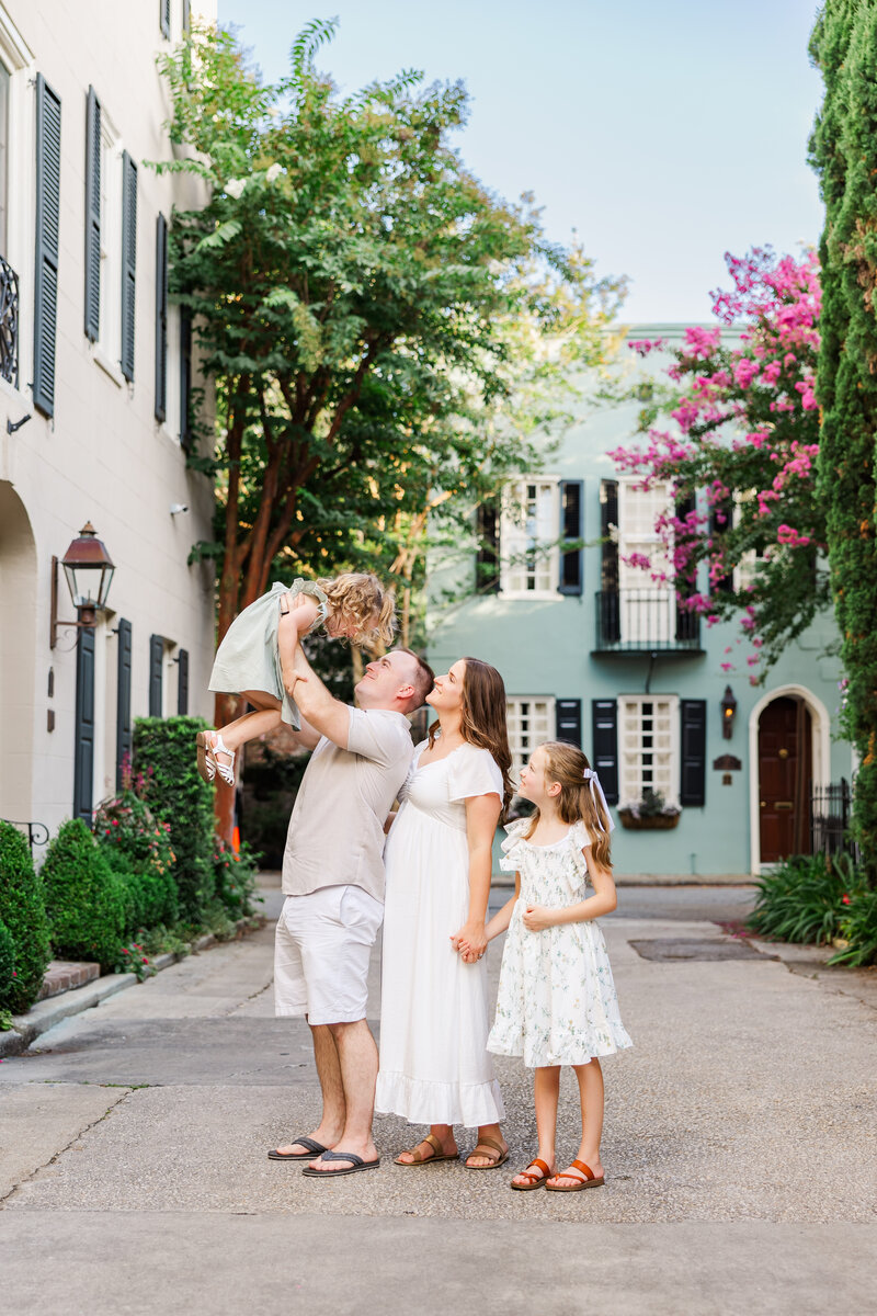 family watching dad holding toddler in downtown Charleston