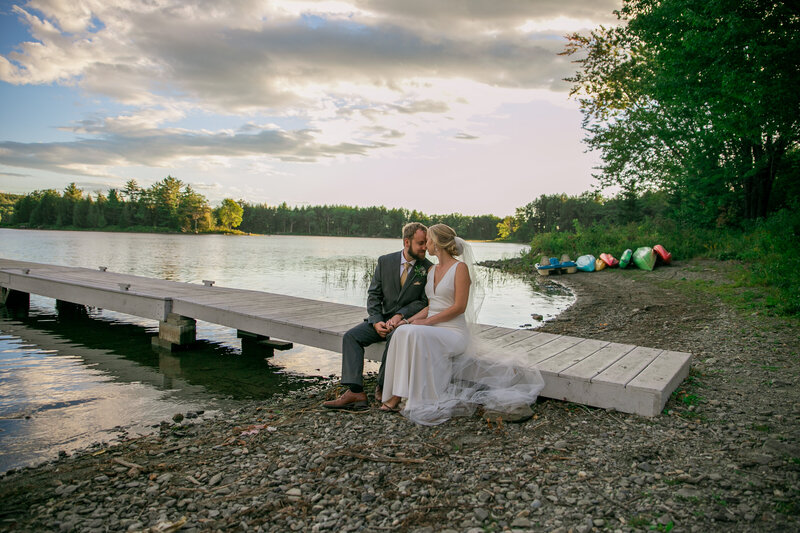 Bride and Groom sitting on dock by the lake | Klein Wedding at Grace on the Lake taken by Wedding Photographer