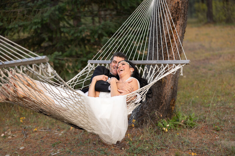 Couple over 40 relaxing in a hammock in the woods during their elopement day