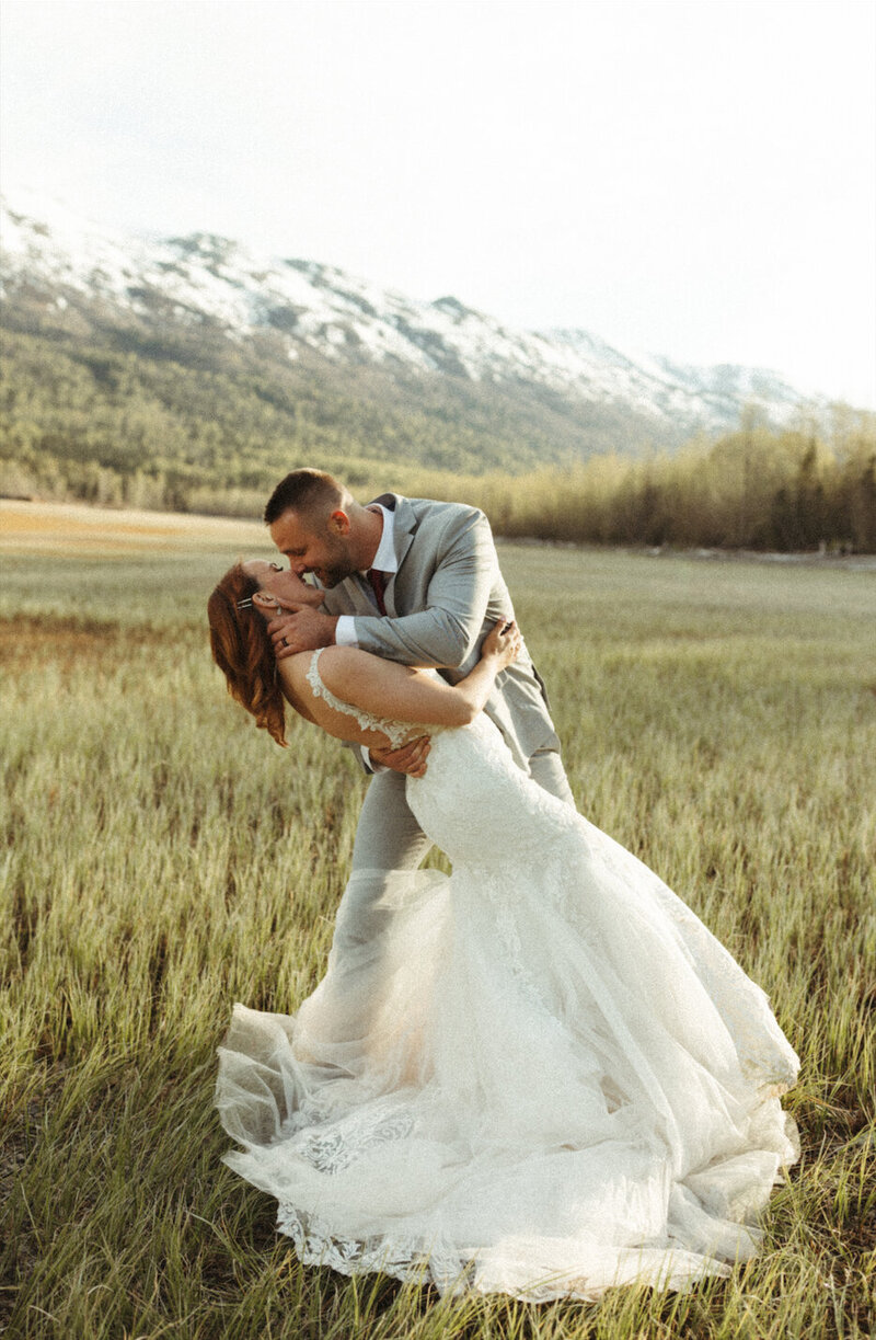 couple snuggling next to mountains during their adventure elopement at Eklutna Lake