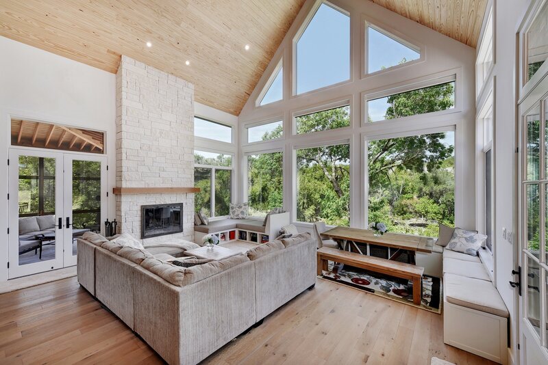 living room with tall windows and a couch near a fireplace