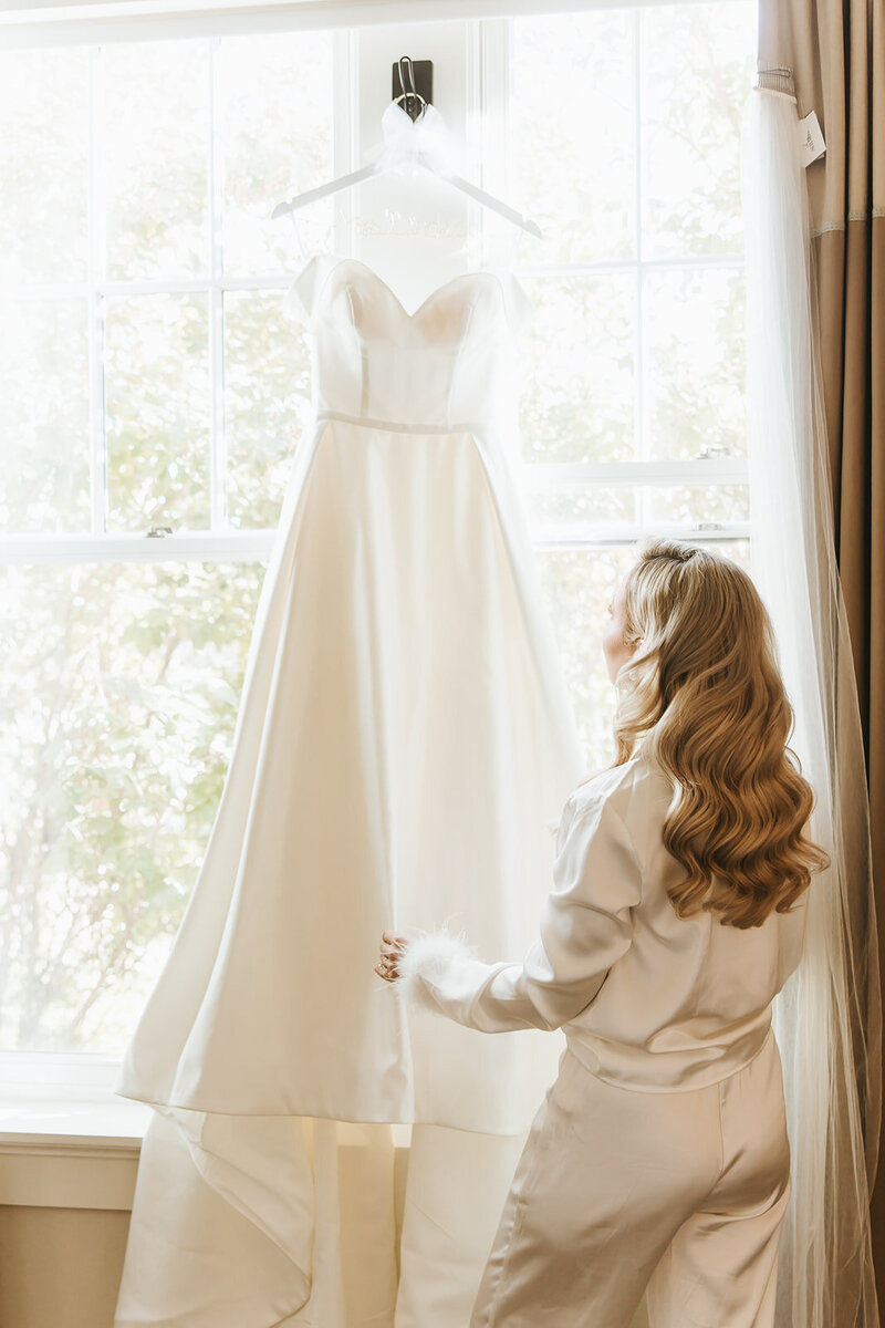 Bride looking at her wedding dress before she puts it on