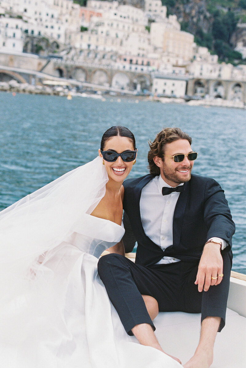 Wedding and Elopement Photographer, couple smiling and wearing sunglasses on the back of a boat