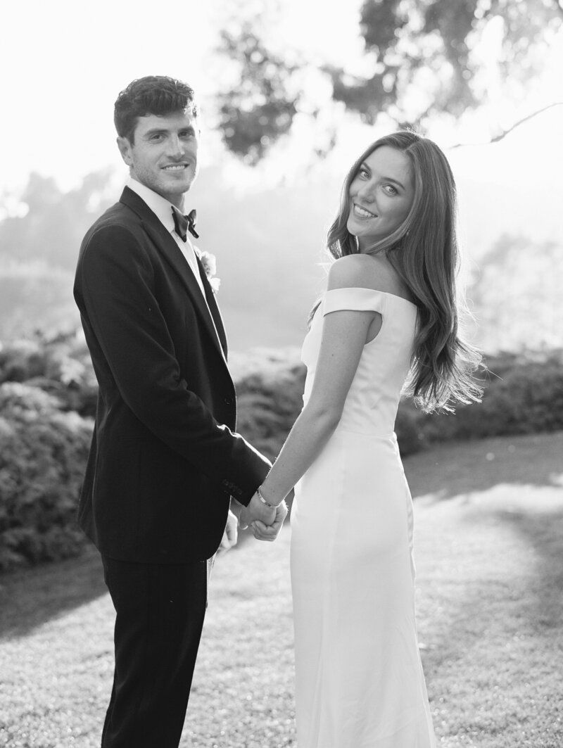 black and white image of couple  on wedding day showing hand beaded gown and sunset
