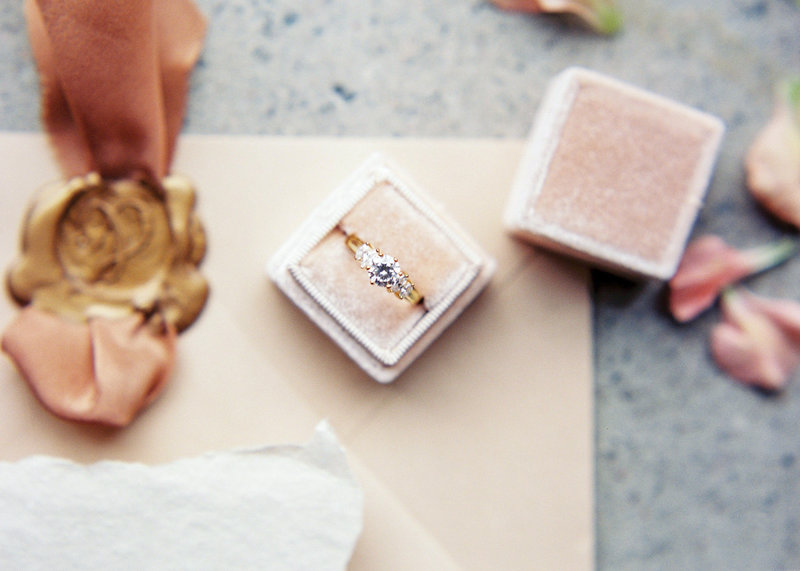 Blush coloured velvet ringbox with a diamond ring in it