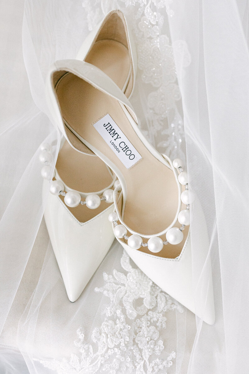 close up of white bridal shoes and lace
