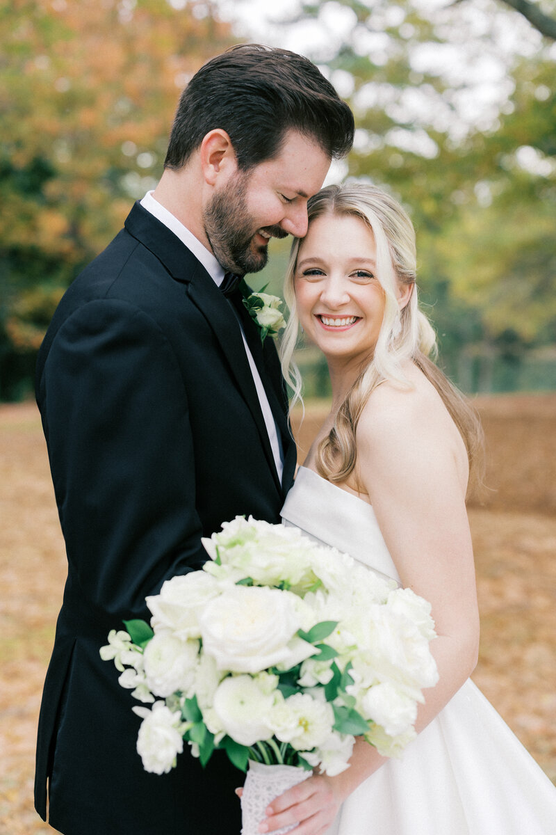 Black and white photo of groom with arm around bride