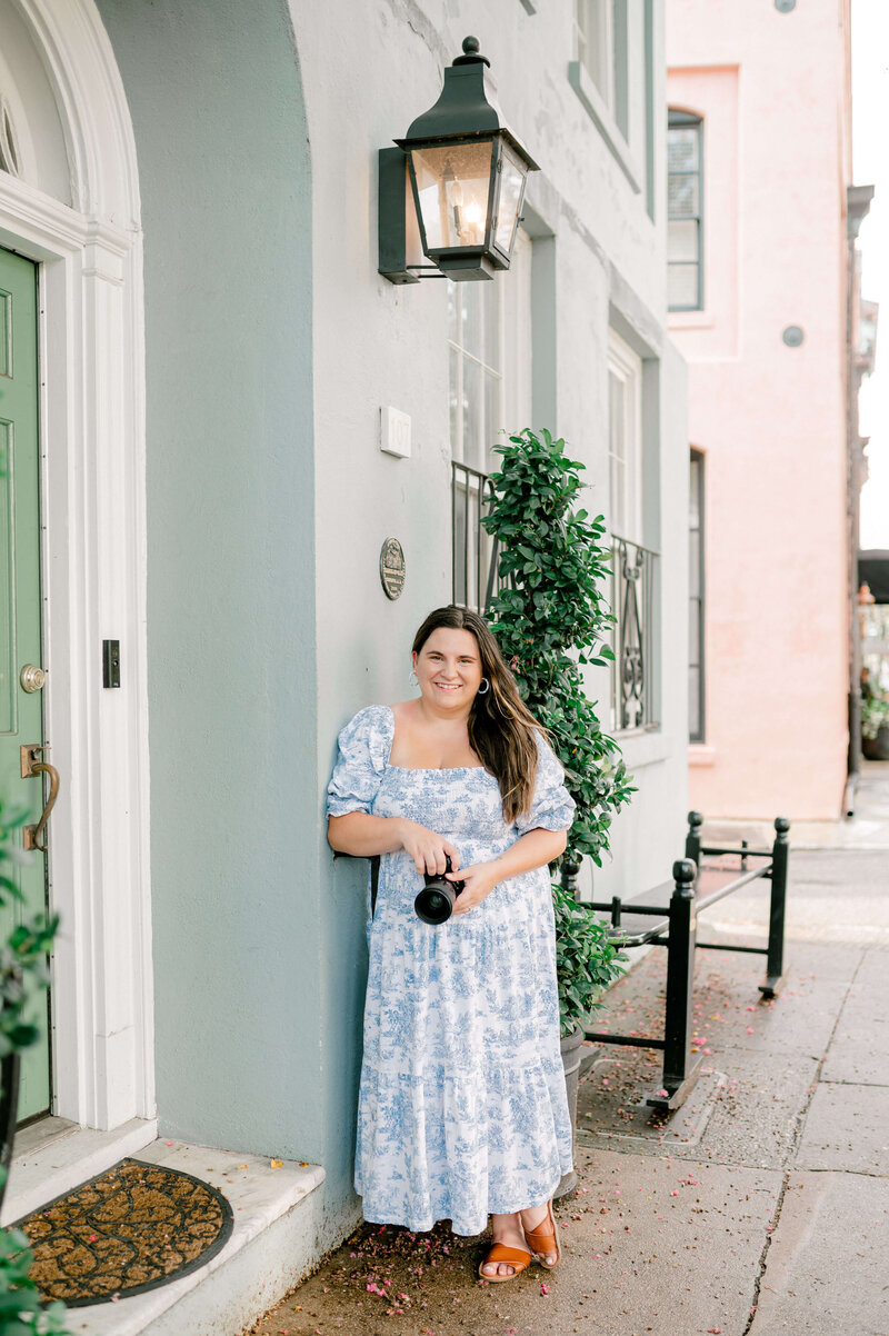 Destination wedding photographer, Rachael Mattion posing for headshot in front of Rainbow Row in Charleston, SC