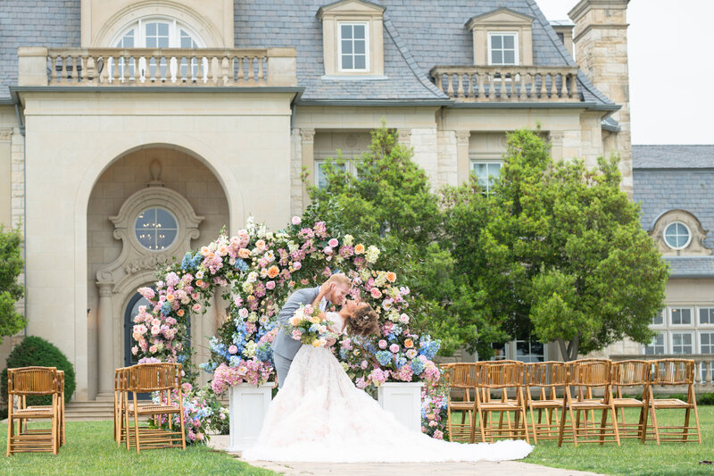 Bride and groom embrace in front of their mansion wedding venue