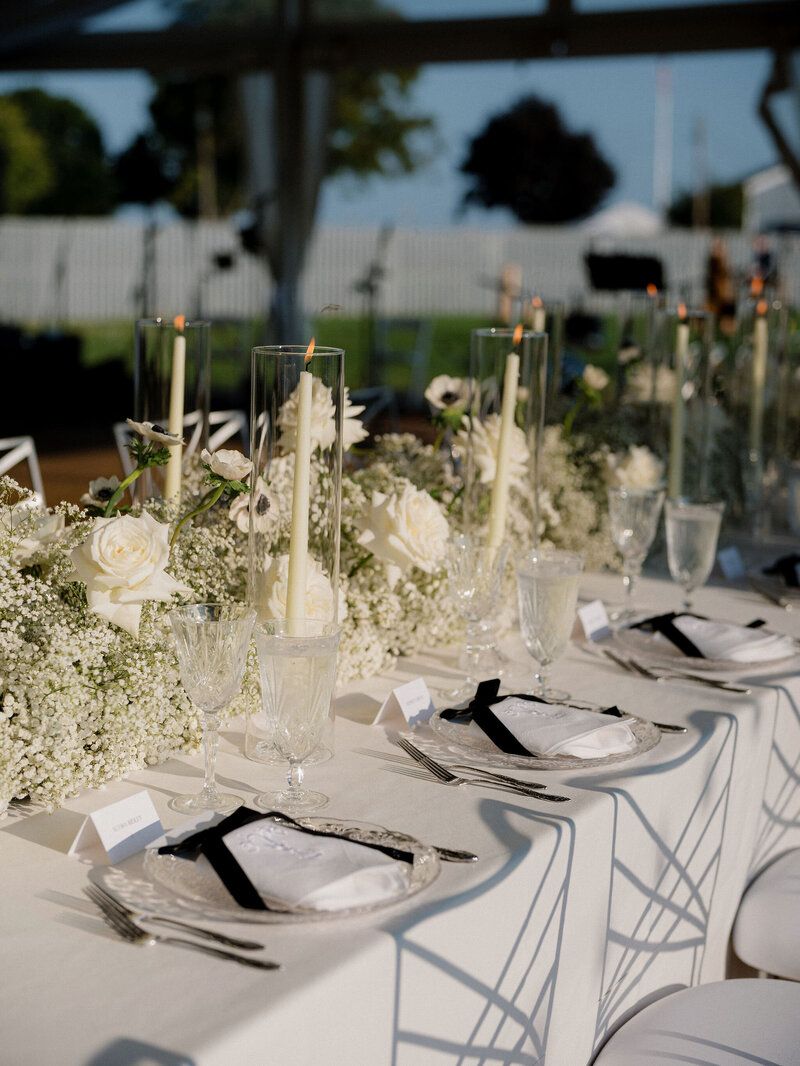Tablescape with neutral florals and candlelight at Connecticut waterfront tented venue 