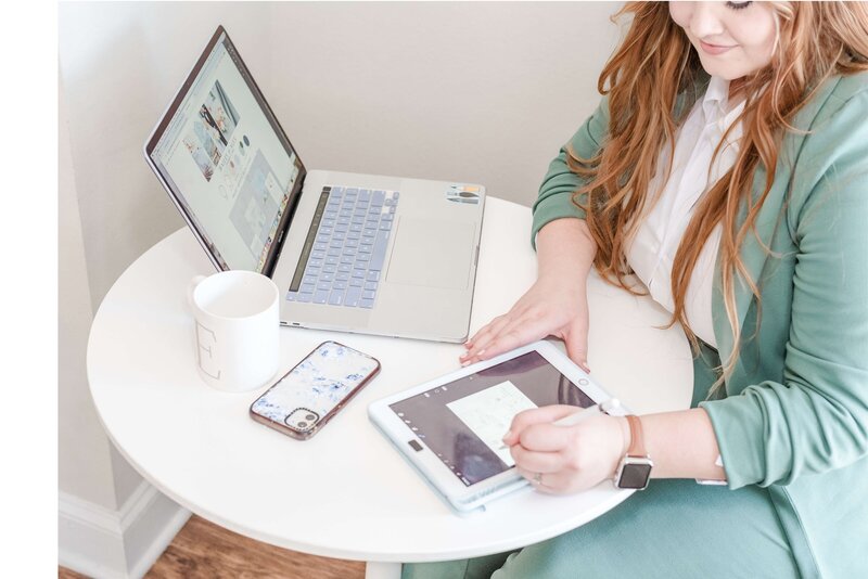 Elyse Stokes working on her tablet to design custom wedding invitations, enjoying the creative process and focusing on client satisfaction