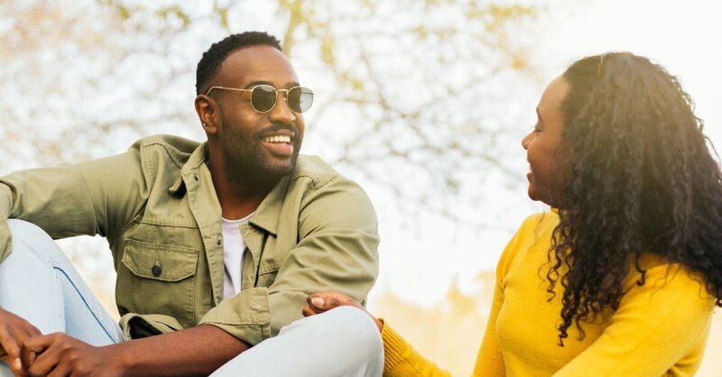 Man sitting alone in a dimly lit room, looking toward the light with a somber expression, symbolizing inner struggle and hope for healing.