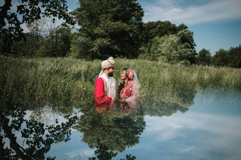 South Asian bride and groom posing for picture outside in New Jersey.