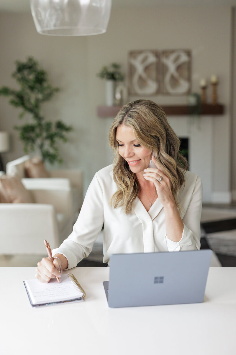 Real Estate agent talking to client on phone while working