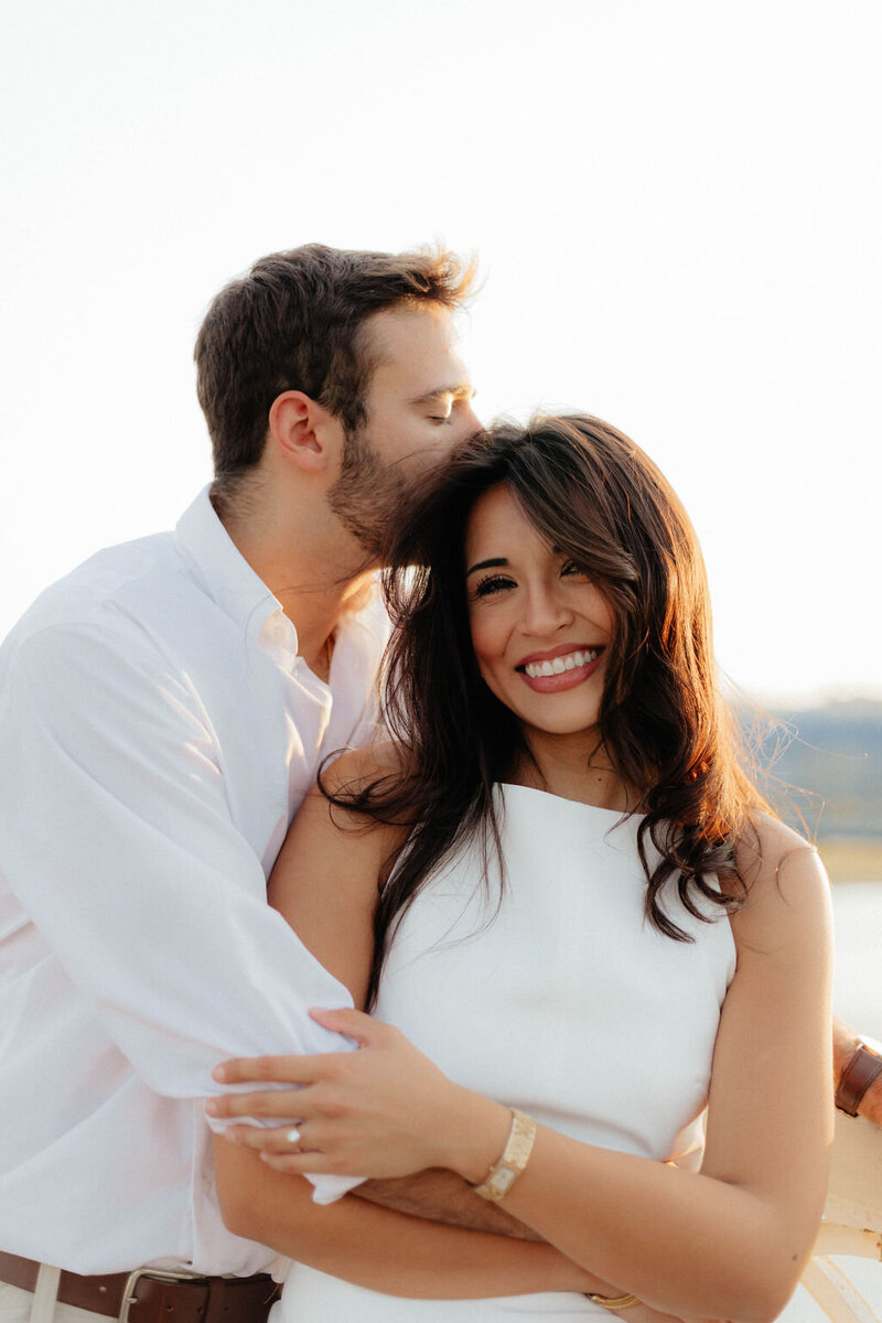 man kissing woman's head