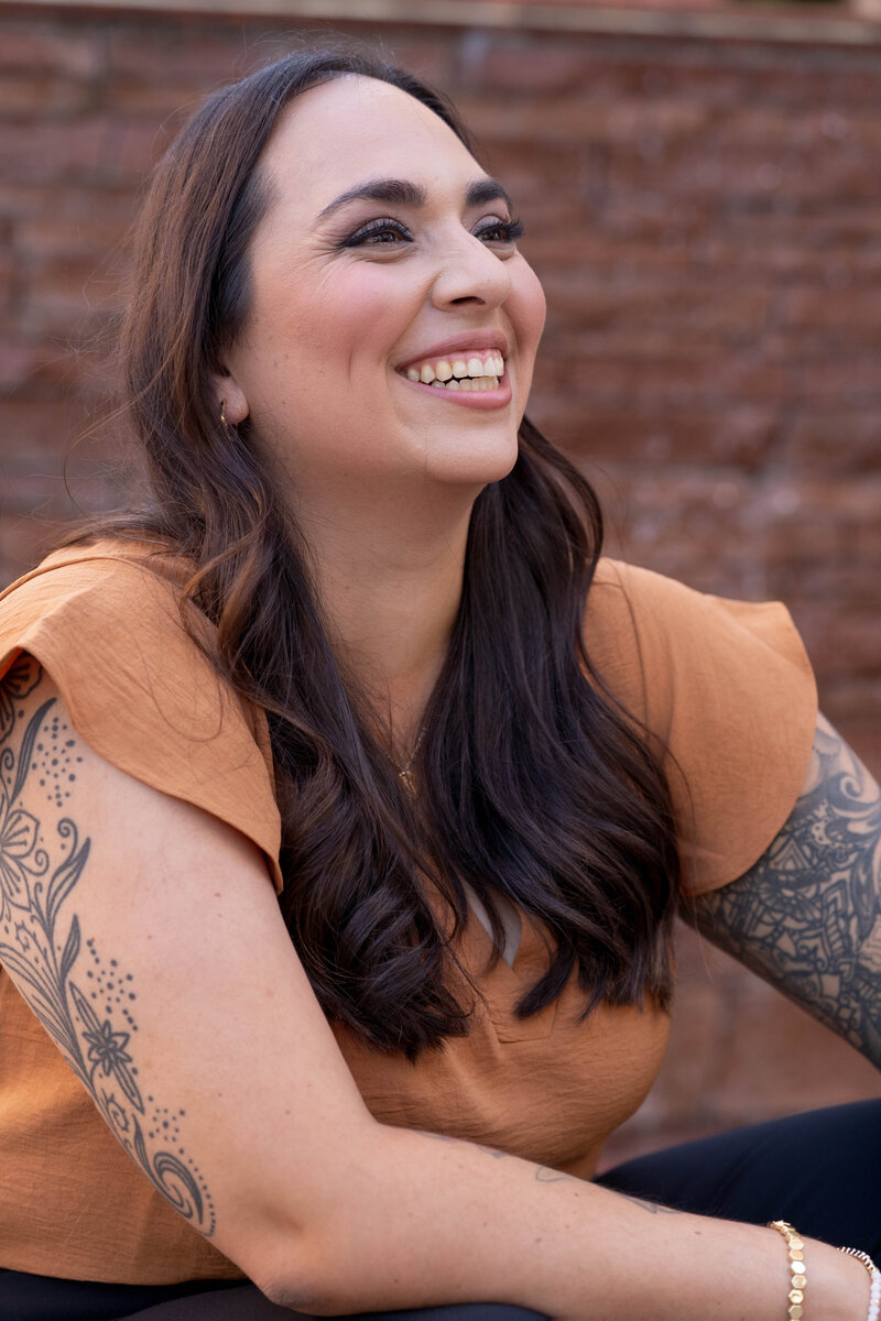 Stephanie, Founder of BCWise Consulting, smiling in an orange shirt