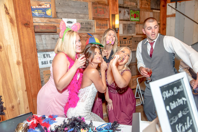People pose for a picture at a photo booth during a wedding