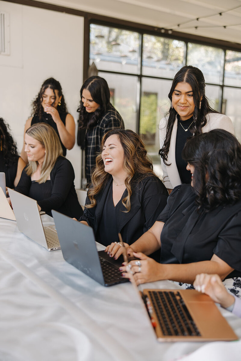 The Abundance Group founders, Ashley Ebert and Dale Henry, smile together behind their desk