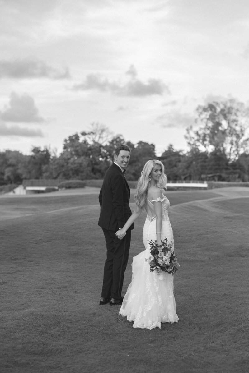 bride and groom embracing while standing on the beach