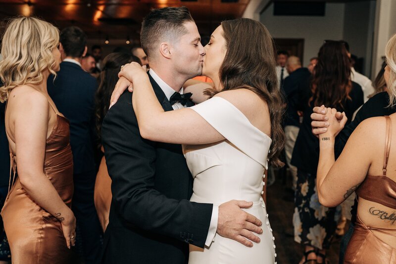 bride and groom kiss while dancing at their wedding reception at the winehouse queenstown