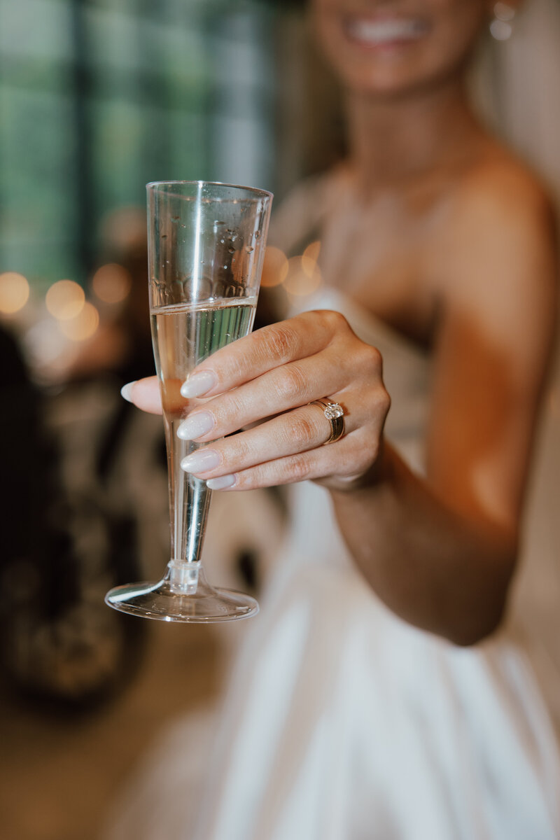 Detail shot of a Champagne glass in a bride's hand