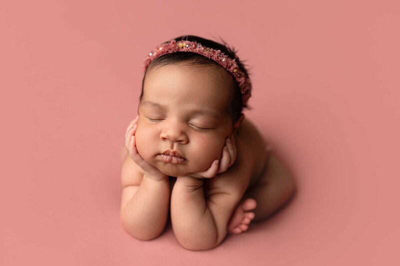 side-lying pose on orange backdrop Charleston newborn photography