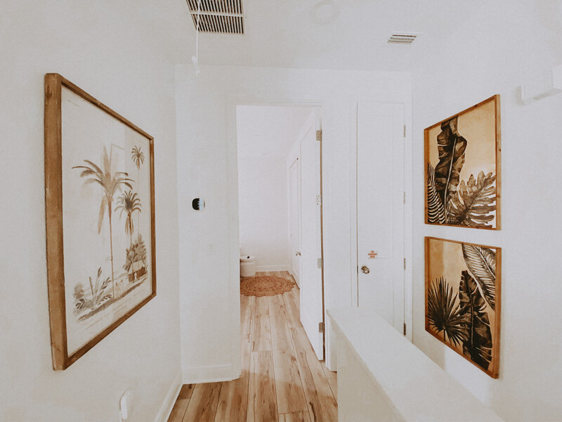 white hallway with artwork of beach landscapes