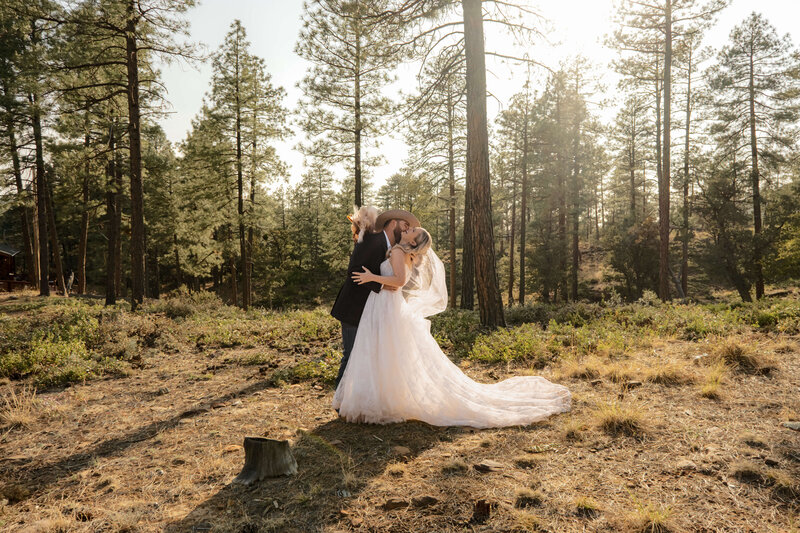 Arizona wedding couple kissing at golden hour with veil blowing in wind.