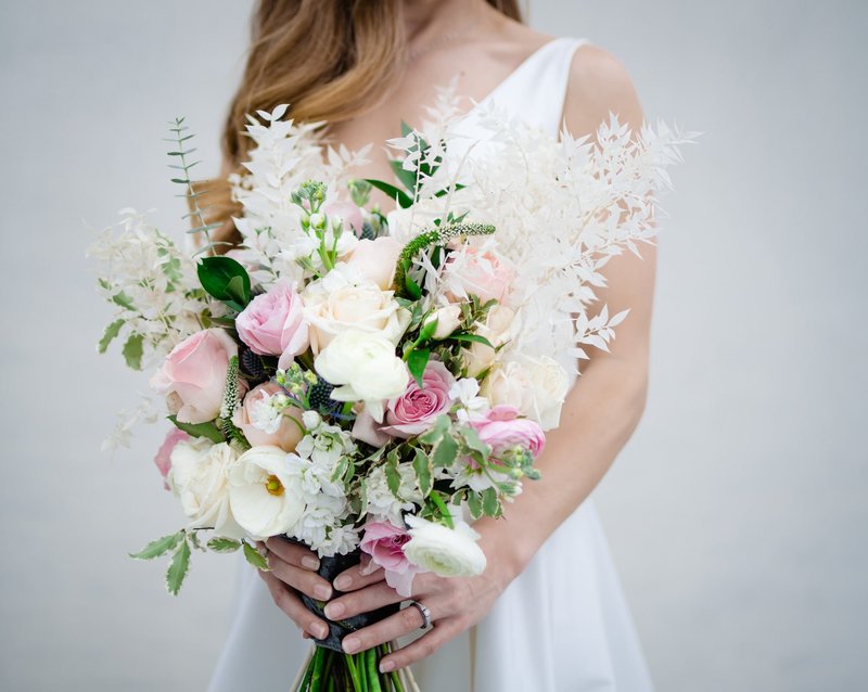 bride holding blush and white bridal bouquet