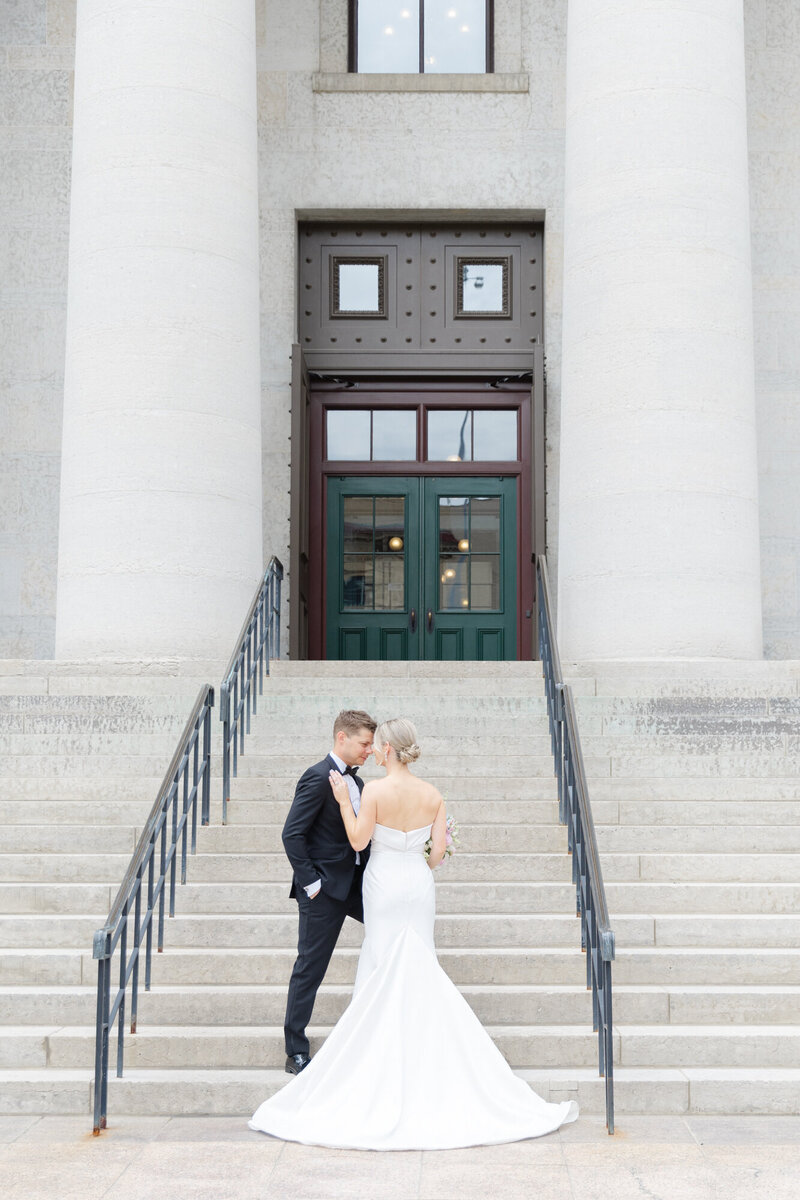 bride and groom with their heads together on the steps of the Ohio Statehouse